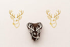 Hand carved wooden deer head stamp with antlers printed in gold ink on textured paper