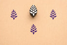 Hand carved small botanical leaf stamp printed in purple ink on textured paper