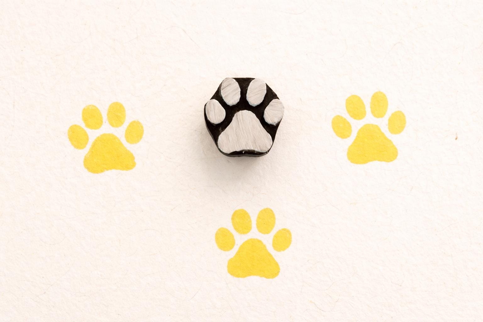 Paw wooden block printing stamp used on fabric and clay showing yellow prints pottery and textile stamp