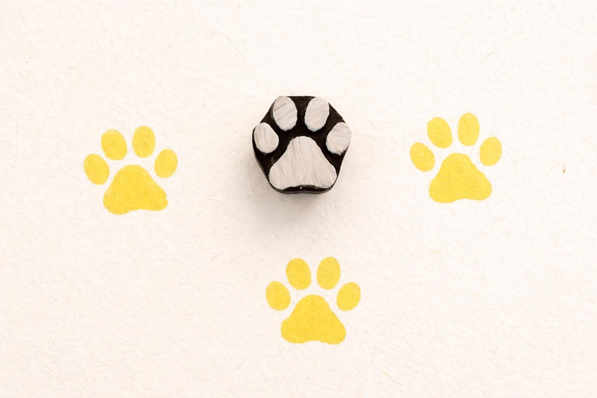 Paw wooden block printing stamp used on fabric and clay showing yellow prints pottery and textile stamp