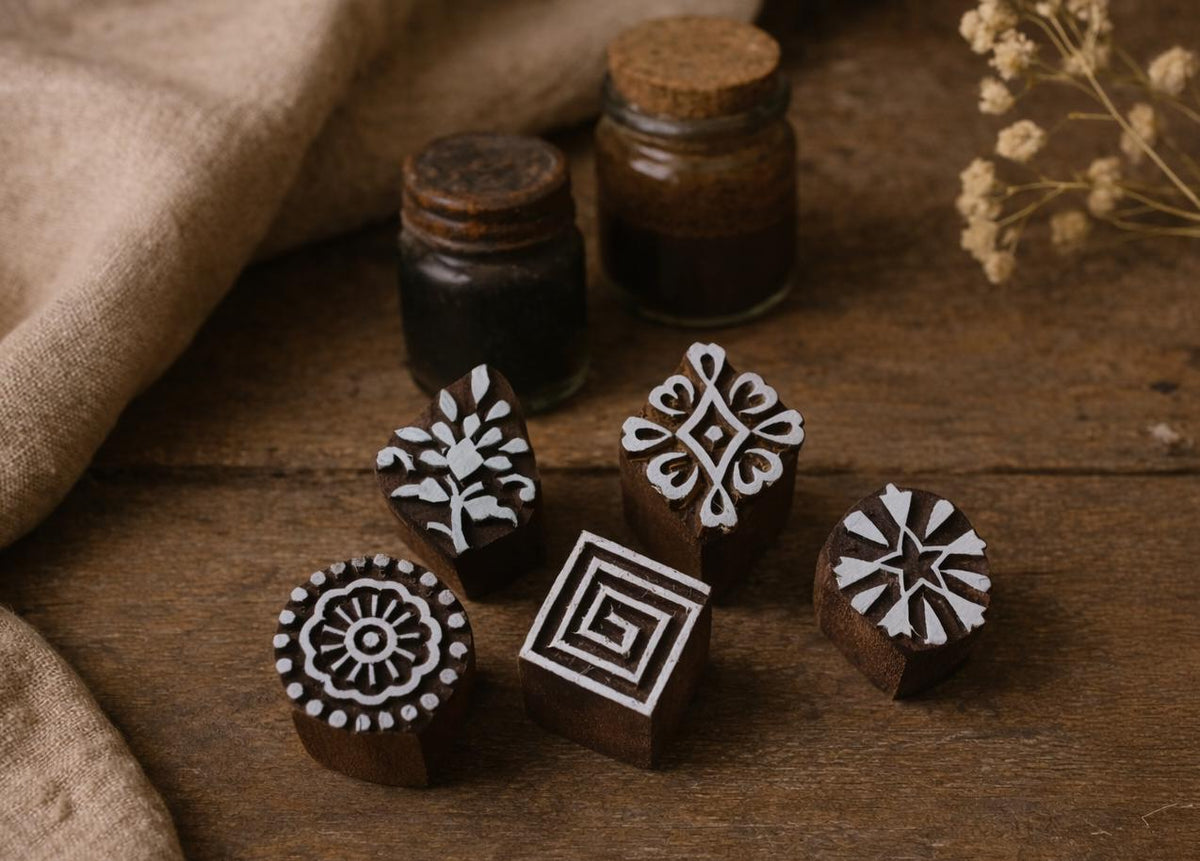 Set of 5 wooden block printing stamps with carved floral and geometric designs on rustic surface