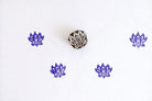 Purple small lotus flower block print pattern on white fabric using wooden stamp