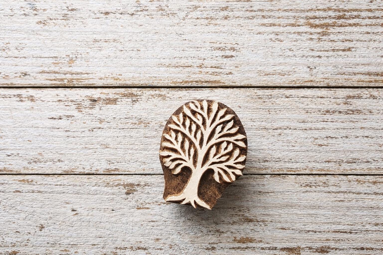 Hand carved wooden tree block printing stamp with detailed branches, shown with on a table, for textile and craft printing