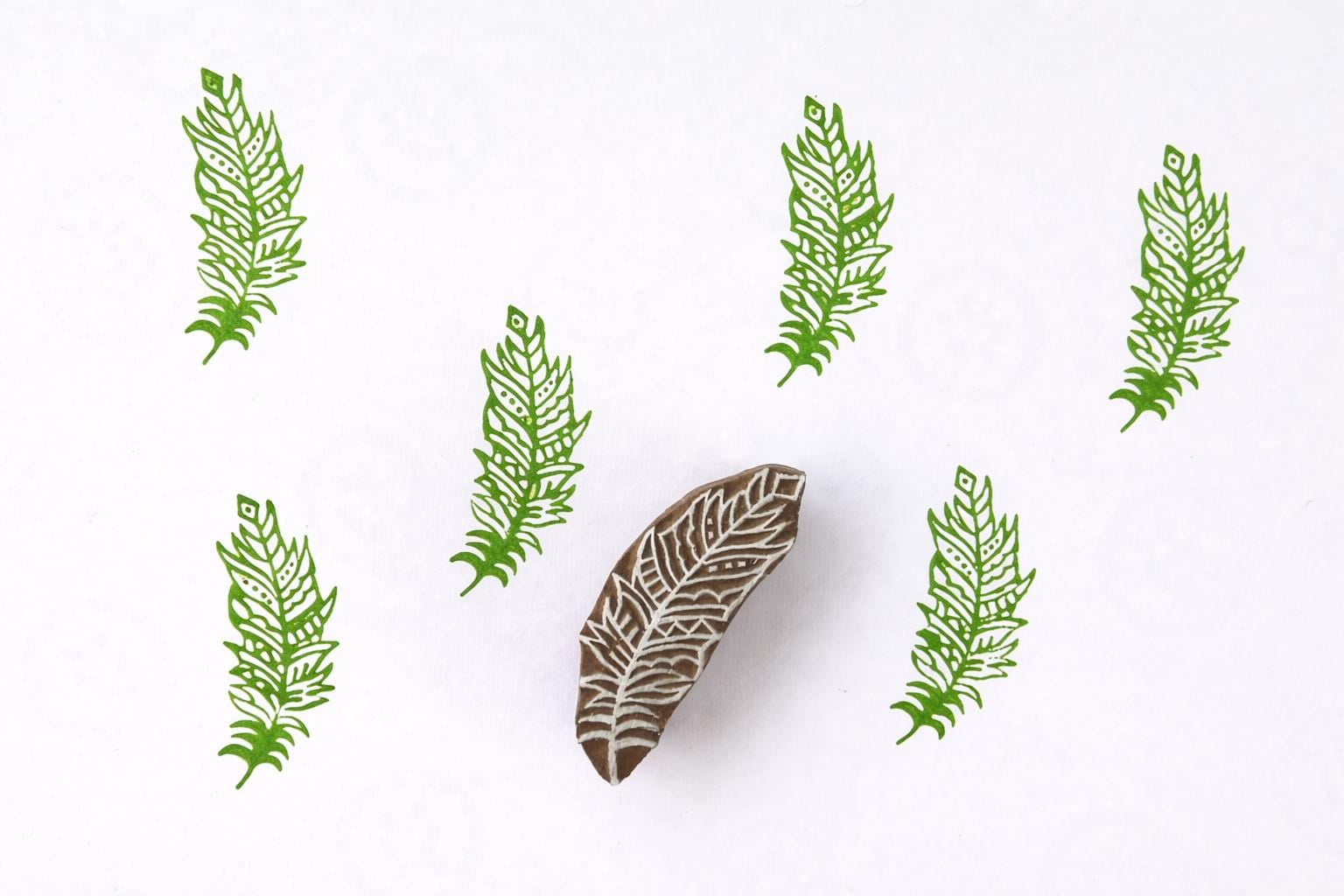 Etched Feather Block wooden stamp creating repeating feather pattern in green ink
