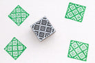 Hand carved wooden stamp printing green diamond geometric pattern on fabric
