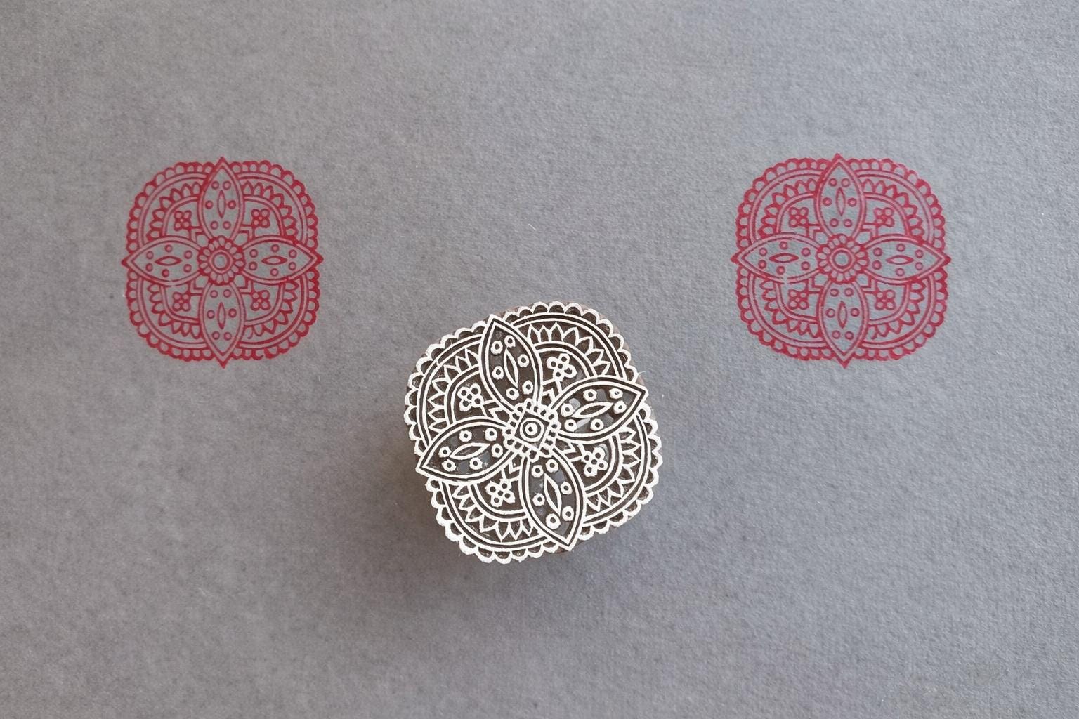Hand carved wooden block printing symmetrical four petal mandala pattern in red