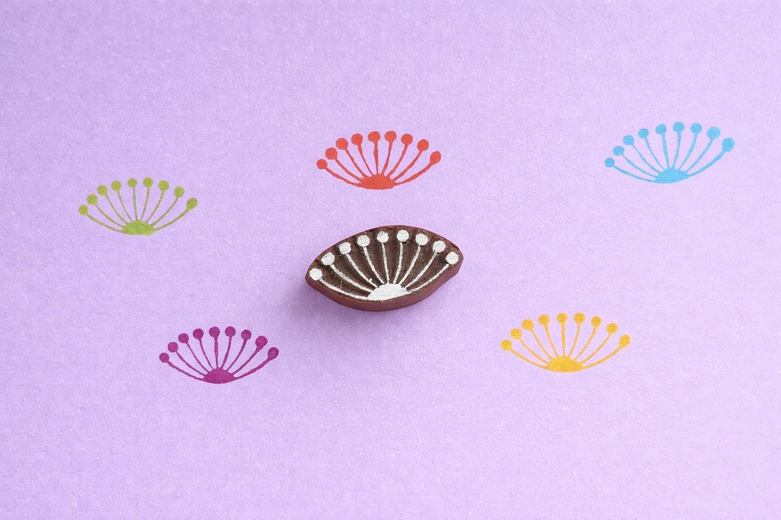 Hand carved wooden stamp printing fan palm or sunburst pattern with radiating dots