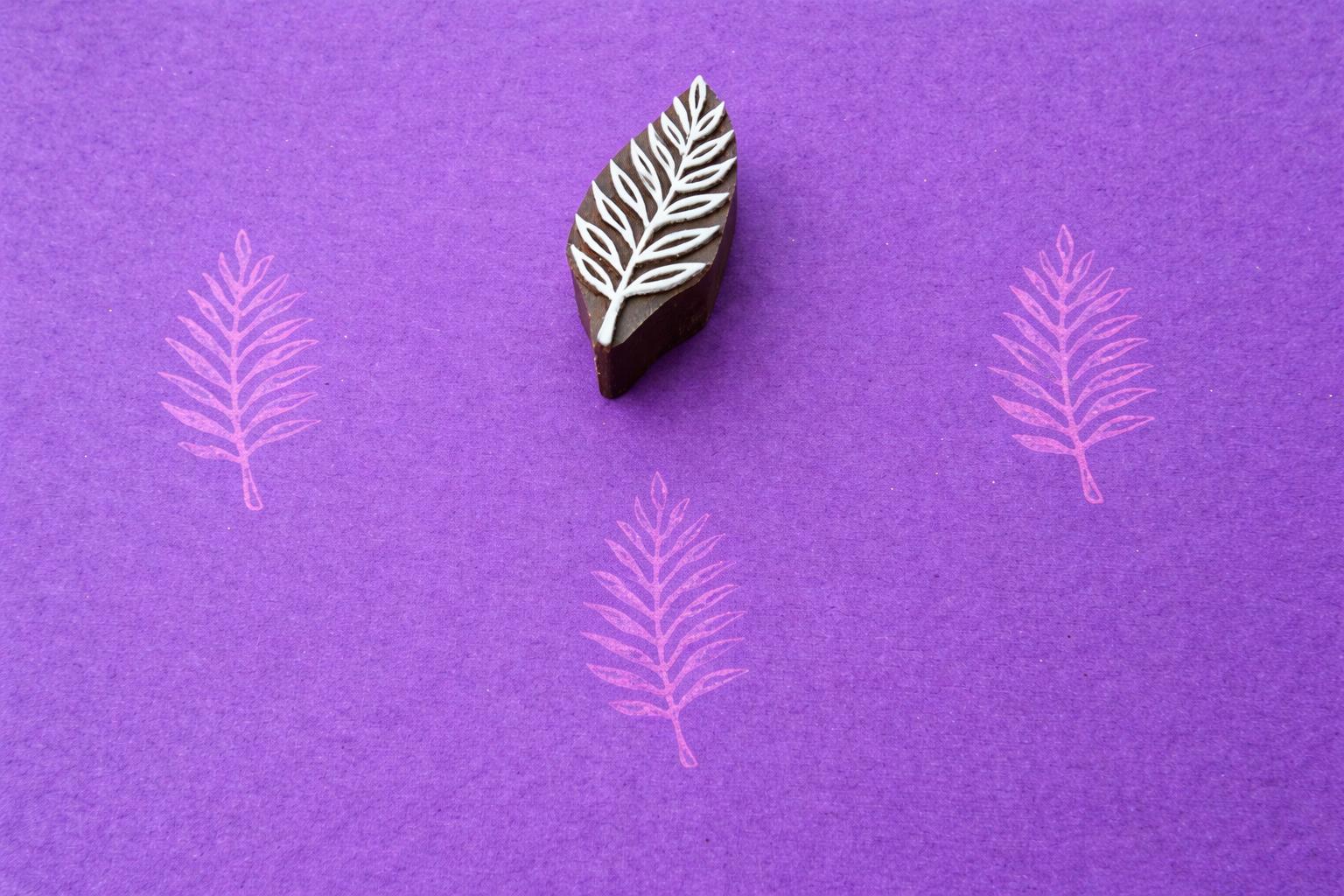 Hand carved wooden stamp printing detailed fern leaf pattern