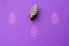 Hand carved wooden stamp printing detailed fern leaf pattern