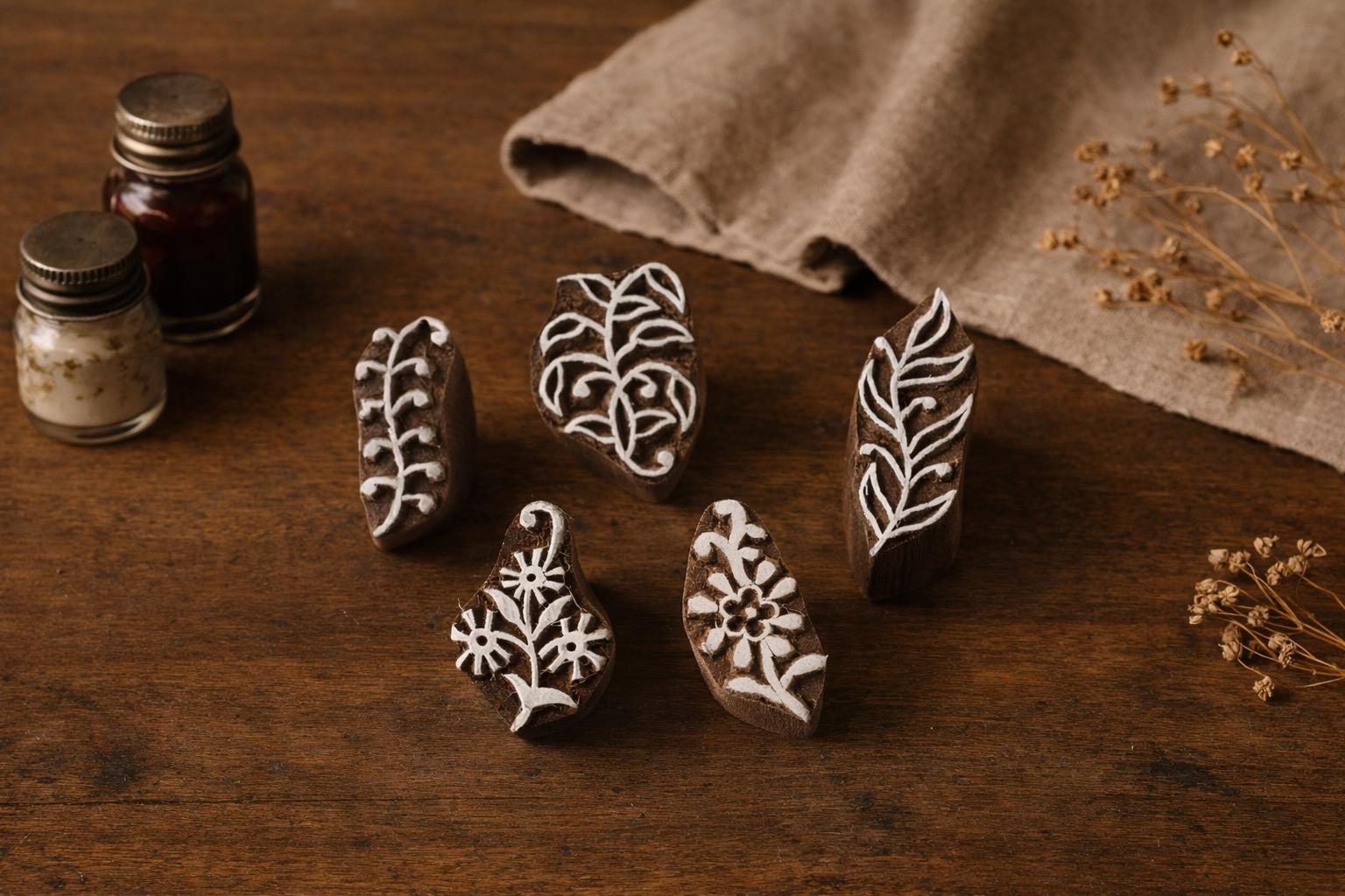 Set of five hand carved wooden block stamps featuring botanical leaf and floral designs used for fabric and paper printing