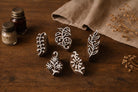 Set of five hand carved wooden block stamps featuring botanical leaf and floral designs used for fabric and paper printing