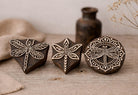 Set of three hand-carved wooden dragonfly block stamps with detailed wing patterns on rustic background