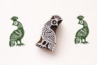 Hand-carved peacock bird wooden stamp with green printed impressions on paper