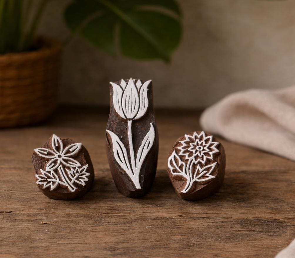 Hand carved floral wood block stamp set with tulip, daisy and wildflower designs on wooden surface
