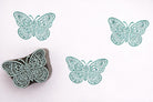 floral butterfly stamp with teal prints on white background