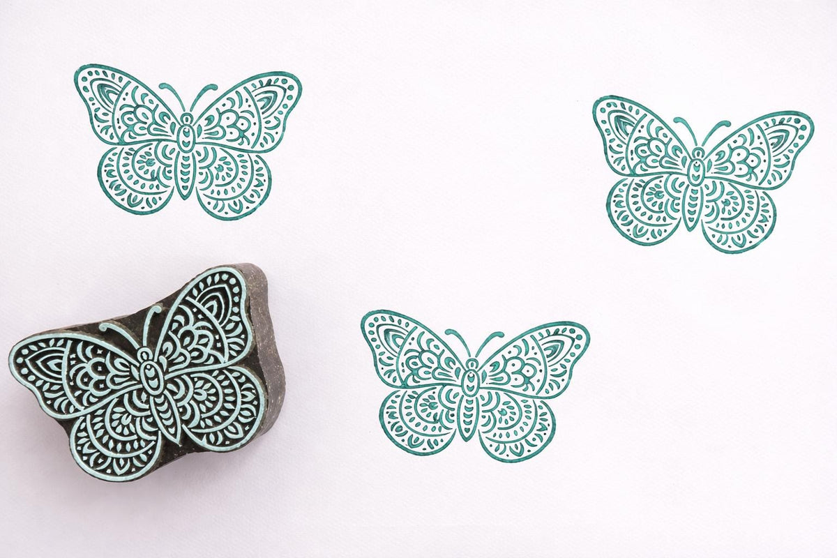 floral butterfly stamp with teal prints on white background