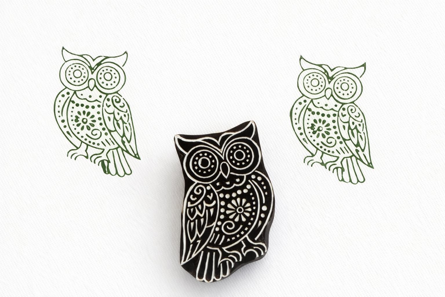 Hand carved wooden owl stamp with intricate decorative details printed in green ink on white paper