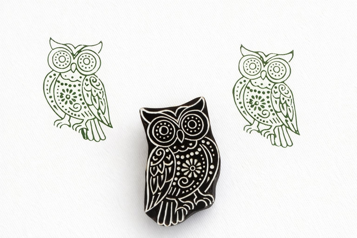 Hand carved wooden owl stamp with intricate decorative details printed in green ink on white paper