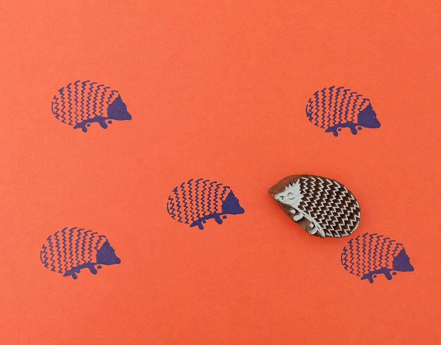 Hand carved wooden printing stamp with hedgehog animal design for fabric printing, textile patterns, and clay pottery