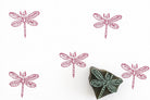 Wooden dragonfly block stamp with pink dragonfly prints on white background