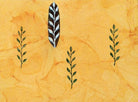 Hand carved long botanical leaf stamp with repeating green prints on textured background