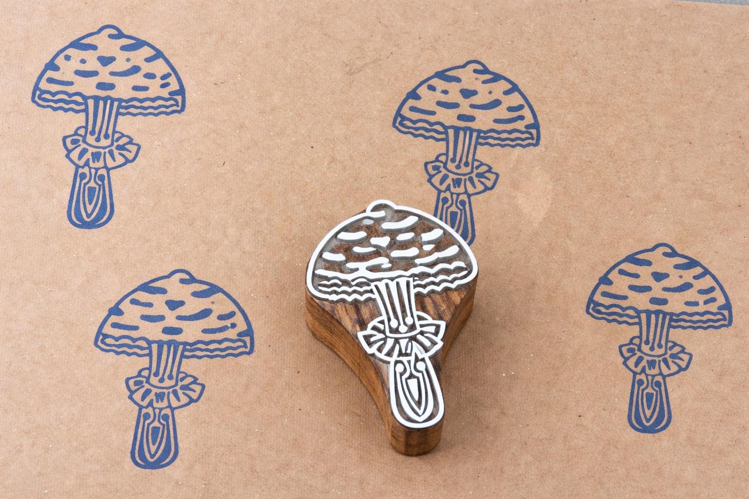 Forest mushroom block print pattern on kraft paper using hand carved stamp