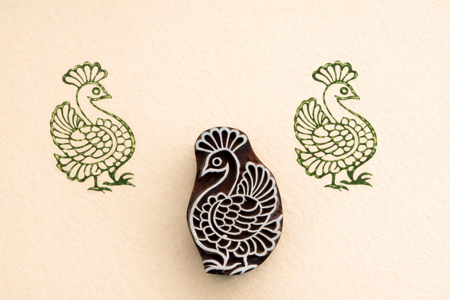 Peacock wooden textile stamp used on fabric showing green block print design Indian printing block