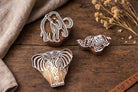 Set of three hand carved Indian elephant wooden block printing stamps on rustic table