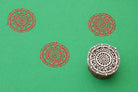 Hand carved wooden stamp creating detailed circular mandala pattern on fabric