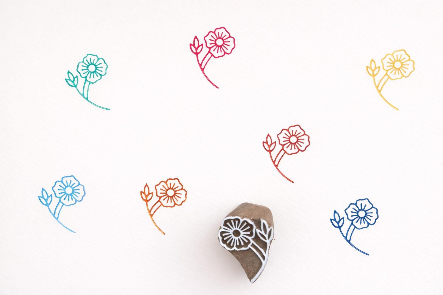 Hand carved wooden stamp printing detailed layered petal flower pattern