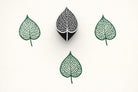 Hand carved Indian wooden block printing tool featuring detailed bodhi leaf vein design, used to create green botanical prints on fabric