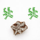 Hand carved Indian wooden printing block with fern leaf botanical design creating green foliage pattern on fabric