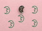 Crescent moon wooden stamp with repeating green moon prints on textured pink paper
