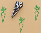 Hand carved carrot stamp with green ink prints on kraft paper