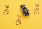 Hand carved wooden block printing stamp featuring a deer motif, used to create repeating animal patterns on fabric, paper, or walls.