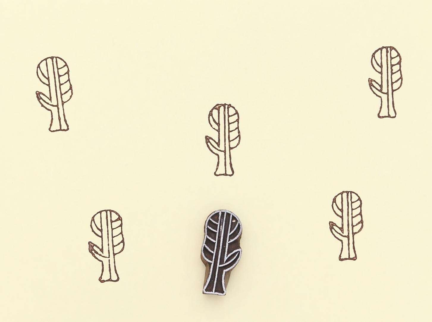 Hand carved wooden printing block making botanical pattern on paper