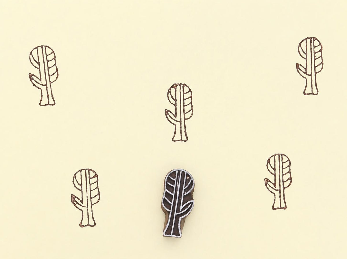 Hand carved wooden printing block making botanical pattern on paper