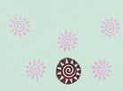 Sun design wooden printing block creating circular pattern on paper