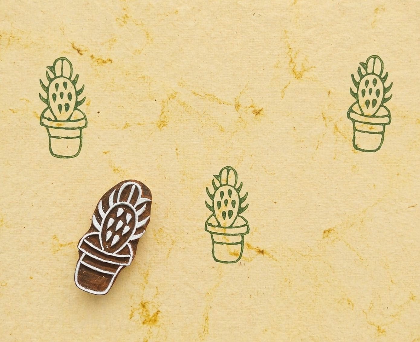 Prickly pear cactus stamp making green repeating pattern on handmade paper