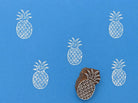 Pineapple wood block stamp with repeating print pattern on blue background