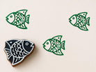 Hand carved wooden printing block with a simple fish illustration for coastal themed fabric printing and repeat patterns.