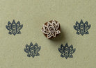 Black small lotus flower block print pattern on paper using wooden stamp