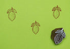 Lemon wooden printing block creating repeating fruit pattern on green background