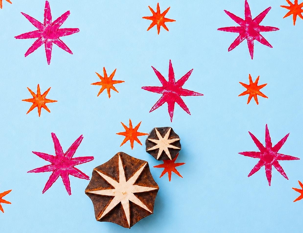 Hand carved Indian wooden printing block set featuring bold celestial starburst patterns printed in pink and orange on blue background for textile printing, pottery, clay, and paper crafts.