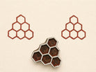 Wooden block print stamp with geometric hexagon cluster creating a clean honeycomb pattern on neutral background