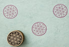 Hand carved Indian wooden block featuring floral lattice circle pattern printed in mauve on handmade blue paper for textile printing, pottery, clay, and paper crafts.