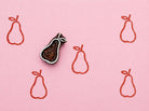 Hand carved wooden pear block stamp printing minimalist fruit pattern in red ink on pink background