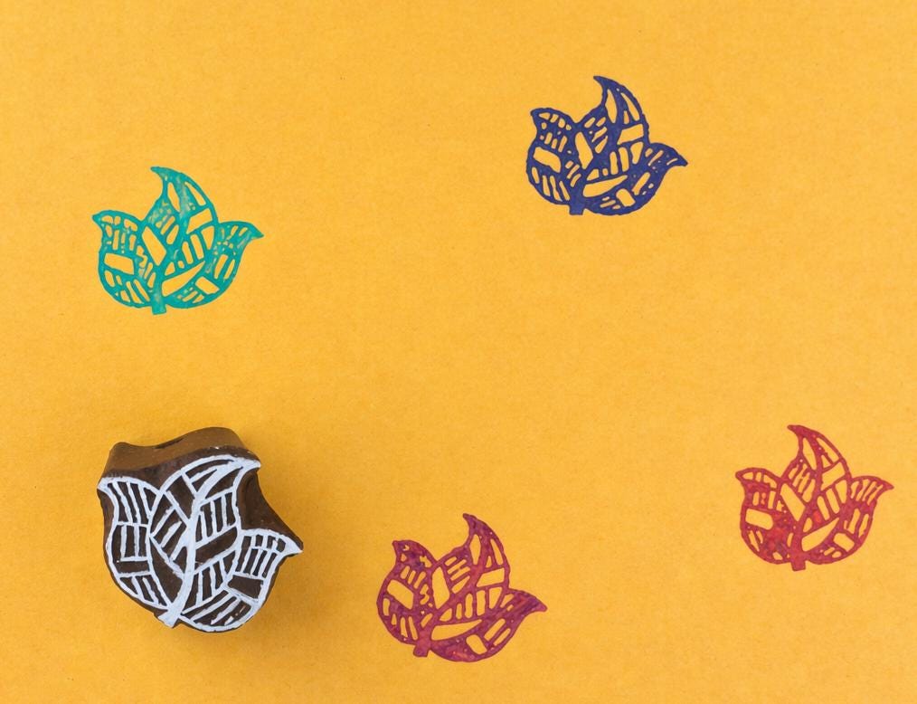Hand carved wooden printing block with a layered folk leaf motif for textile printing, paper crafts, and botanical surface patterns.