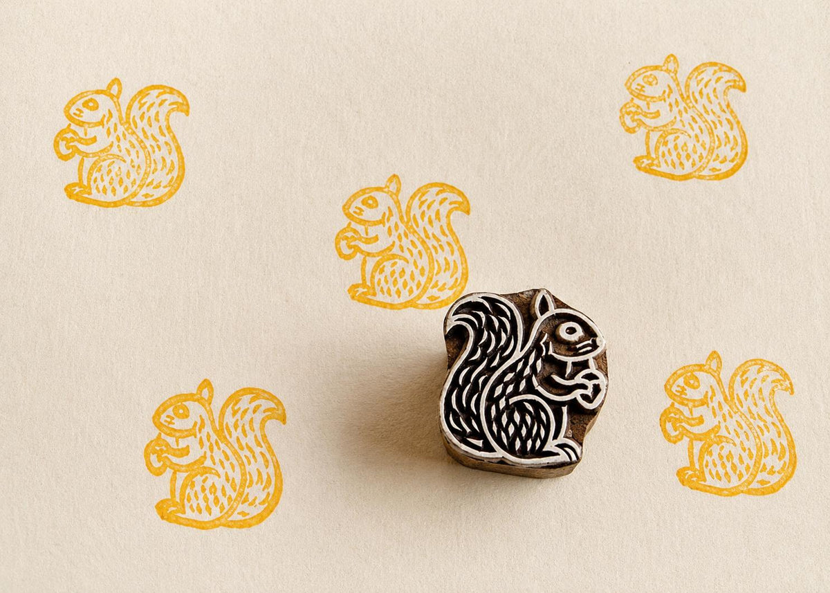 Hand carved  Squirrel block stamp with repeating folk squirrel impressions on handmade paper
