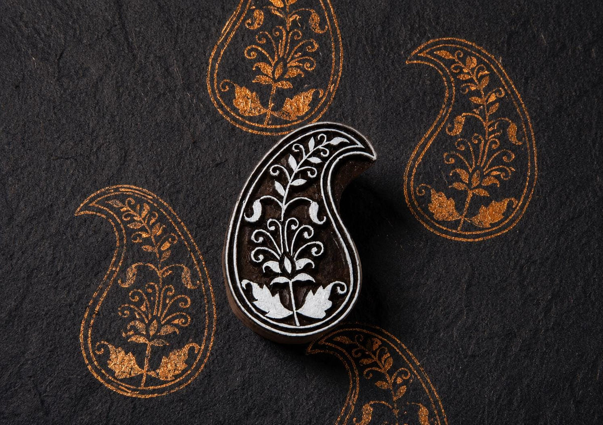 Hand carved Bloomvine Paisley block stamp with repeating folk floral paisley impressions printed on handmade paper